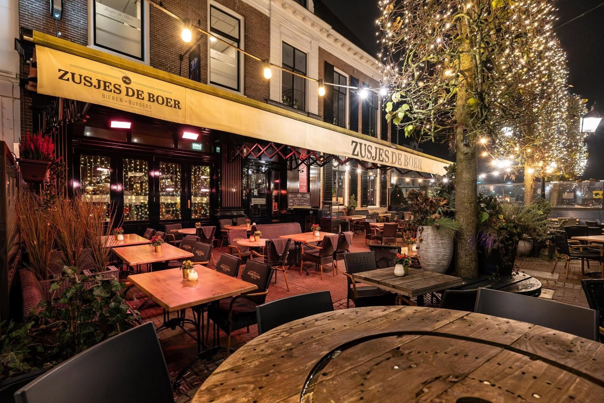 Het verlichte terras van Zusjes de Boer aan de Markt in Assen